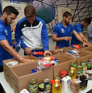 שחקני מכבי והפועל פ"ת מתנדבים באריזת חבילות מזון לנזקקים 
